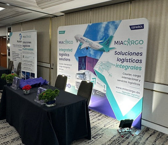A conference room or exhibition space with a large MIACARGO promotional display stand.