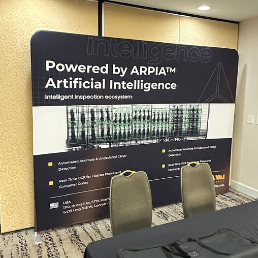 A conference room setup featuring a large black and white 'Powered by ARPIA Artificial Intelligence' display board on the wall.